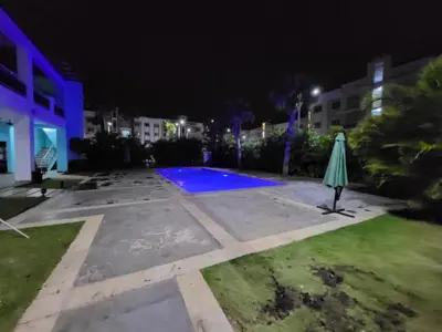 an empty pool at night with an umbrella at Oasis Palma Real santiago, Republica Dominicana in Santiago de los Caballeros