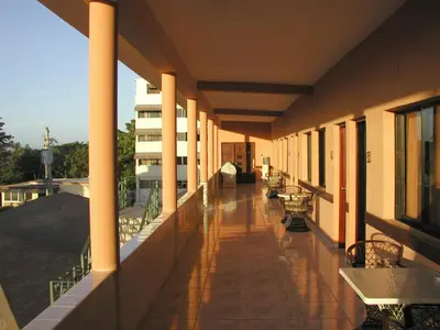a balcony with tables and benches on a building at Hotel Garant & Suites in Boca Chica