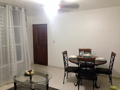 a dining room with a table and chairs and a table and a dining room at Caribbean Seaview apart Malecon Santo Domingo in Santo Domingo
