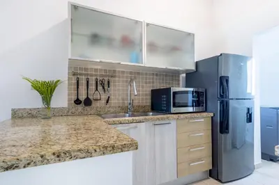 a kitchen with a sink and a refrigerator at Private & Luxury Apartment Cocotal in Gated & Secured Community in Punta Cana