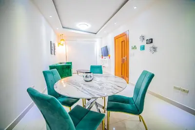 a dining room with a table and green chairs at SFMverdana Rental in San Francisco de Macorís