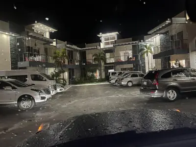 a parking lot with cars parked in front of buildings at SFMverdana Rental in San Francisco de Macorís