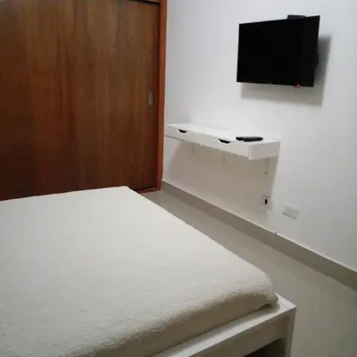 a bedroom with a bed and a flat screen tv at Cozy apartment in exclusive area Bella Vista in Santo Domingo