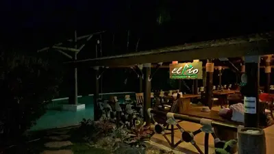 a restaurant with a lit up sign at night at Platon Ecolodge in Santa Cruz de Barahona