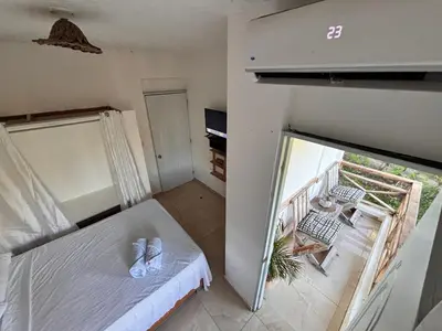 a small bedroom with a bed and a balcony at Villa Coconut in La Verita