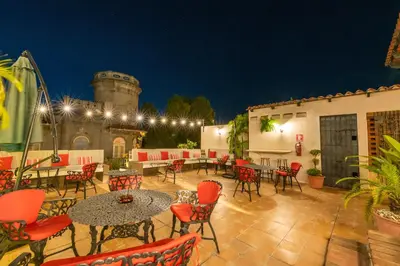 a patio with red chairs and tables and a building at El Beaterio Casa Museo in Santo Domingo