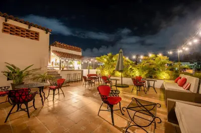 a patio with chairs and tables at night at El Beaterio Casa Museo in Santo Domingo