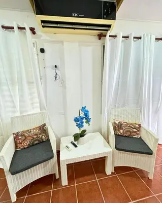 two wicker chairs and a table with a vase of flowers at Hotel Santo Cerro Natural Park in Santo Cerro