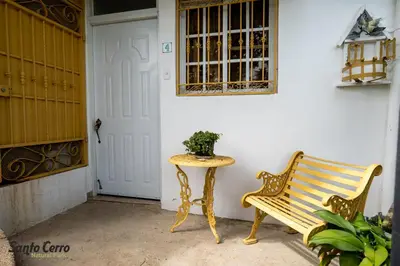 a bench and a table in front of a door at Hotel Santo Cerro Natural Park in Santo Cerro