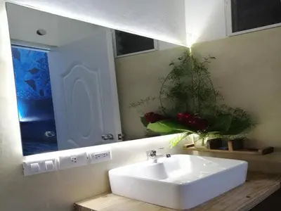 a bathroom with a white sink and a mirror at House Jardin Del Caribe in Las Terrenas