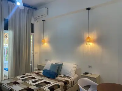 a bedroom with a bed and two lights on the wall at Apartamentos Magallanes Bayahibe in Bayahibe