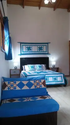 a bedroom with two blue beds with blue sheets at Mi Hogar Jarabacoa in Jarabacoa
