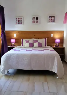 a bedroom with a large white bed with two lamps at Mi Hogar Jarabacoa in Jarabacoa