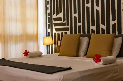 a bedroom with a large bed with red flowers on it at Afreeka Beach Hotel in Las Terrenas
