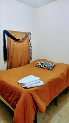 a bed with two white towels on top of it at Apartahotel carla in Boca Chica