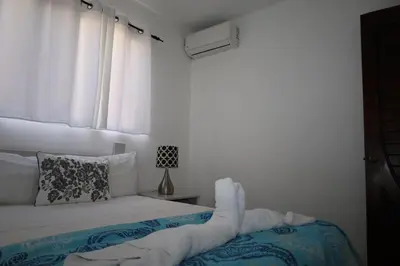 a white bedroom with a bed and a window at Aparta-Hotel Villa Baya in Bayahibe