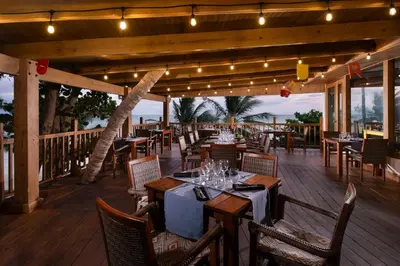 a restaurant with tables and chairs on a deck at Impressive Premium Punta Cana - All Inclusive in Punta Cana
