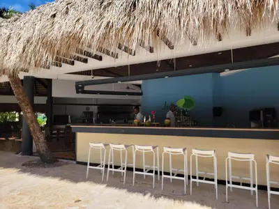 a bar with white stools in front of a restaurant at Impressive Premium Punta Cana - All Inclusive in Punta Cana