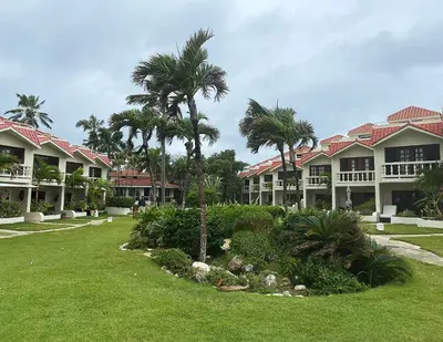 a row of houses with palm trees in a yard at Cabarete Beachfront Condos at Nanny Estate C-5 in Cabarete