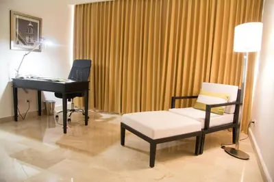 a room with a piano and a chair and a table at Radisson Hotel Santo Domingo in Santo Domingo