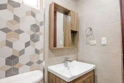 a bathroom with a sink and a toilet and a mirror at Dolce Villas at Harmony 2 in Santiago de los Caballeros