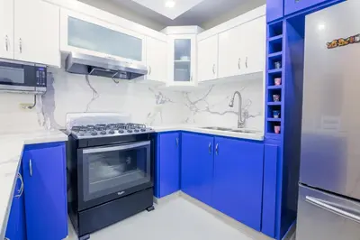 a kitchen with blue cabinets and a stove at Dolce Villas at Harmony 2 in Santiago de los Caballeros