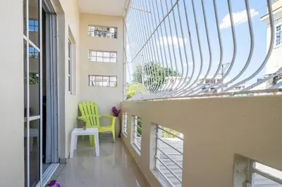 a balcony with a yellow chair and a window at Cerca del Mar, Obelisco Hembra y Zona Colonial in Santo Domingo