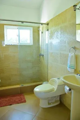 a bathroom with a toilet and a sink and a shower at Villa Vista azul Sosua in Sosúa