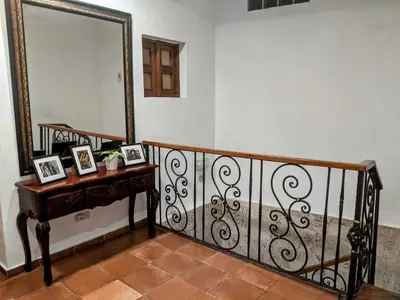 a staircase with a mirror and a table with pictures on it at Hotel Aluge in Santo Domingo