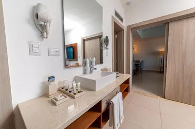 a bathroom with a white sink and a mirror at Presidential Suites Cabarete - Room Only in Cabarete