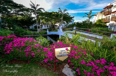 a sign in a garden with pink flowers at Pez 106 in Bayahibe