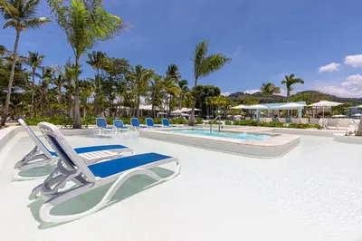 a swimming pool with lounge chairs and a resort at Senator Puerto Plata in San Felipe de Puerto Plata