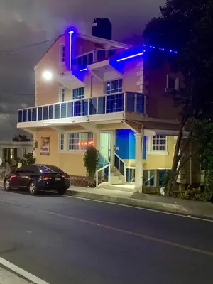 a building with a car parked in front of it at Hotel Vista Sur in Los Patos