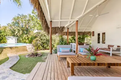 an outdoor patio with a wooden table and chairs at Caribbean Beach Villa Playa Bonita Las Terrenas in Las Terrenas