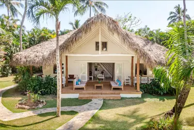 a villa with a thatched roof and a patio at Caribbean Beach Villa Playa Bonita Las Terrenas in Las Terrenas