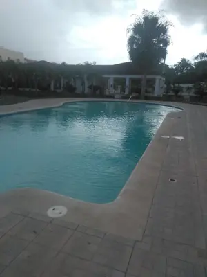 a swimming pool with blue water in front of a house at PARADISE 3 Cerro Altos in Santiago de los Caballeros