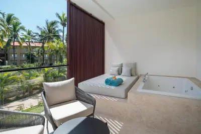 a balcony with a tub and a bed and a chair at Live Aqua Punta Cana - All Inclusive - Adults Only in Punta Cana