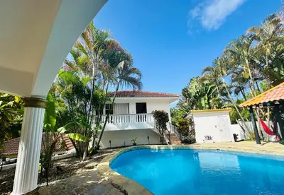 a swimming pool in front of a house at HappiCasaRD & Holistic House in Sosúa