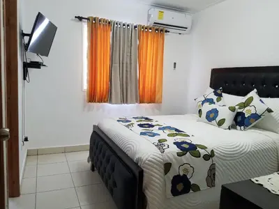 a bedroom with two beds and a television in it at Aprtamento Deluxe Santiago, Residencial Palma Real R402 in Santiago de los Caballeros