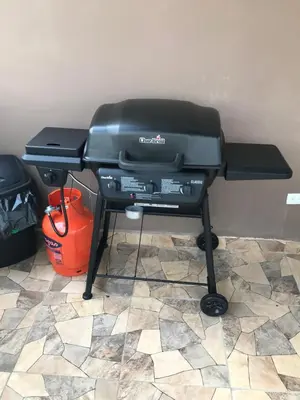 a charcoal grill on a stand with a bucket at Aprtamento Deluxe Santiago, Residencial Palma Real R402 in Santiago de los Caballeros