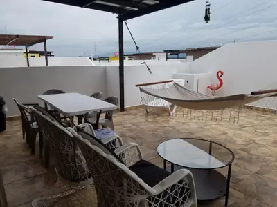 a patio with tables and chairs and a hammock at Ave. Duarte k3/12, Residencial Palma Real, Santiago, RD in Arenoso