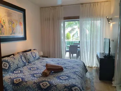 a bedroom with a bed with a purse on it at Palmeraie Terrenas Beach Apartment in Las Terrenas