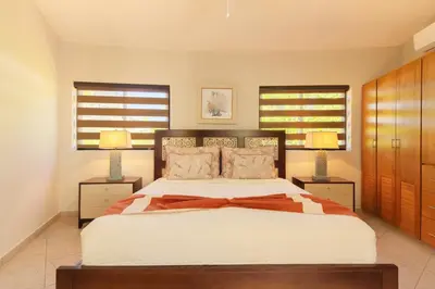 a bedroom with a large bed with two lamps at 883 Residencial Casa Linda in Sosúa