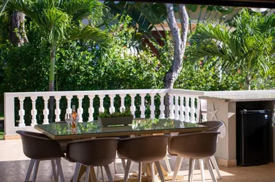 a table and chairs on a patio with a fence at 883 Residencial Casa Linda in Sosúa