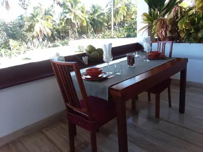 a dining room table with two chairs and a table with fruit on it at Oasi Encantada - Beach Resort in Santa Cruz de Barahona