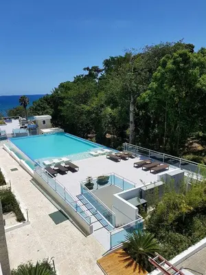 a large swimming pool with lounge chairs and a swimming poolvisor at Koko and Suzy's ocean dream in Laguna del Higüero