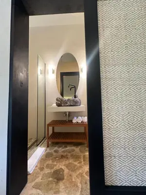 a bathroom with a mirror and a bench in a room at El Rincon de Abi in Las Terrenas