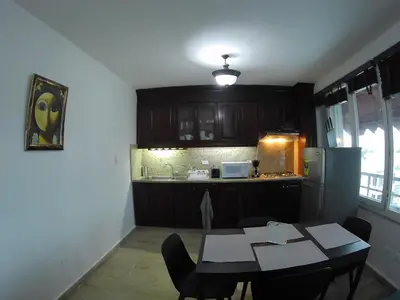 a kitchen with a table with chairs and a refrigerator at Hotel Discovery in Santo Domingo