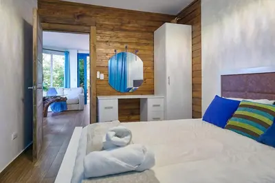 a bedroom with a large bed and a mirror at Mansion Dubai-Mountain-Jacuzzi-4BR-Jamaca De Dios in Jarabacoa