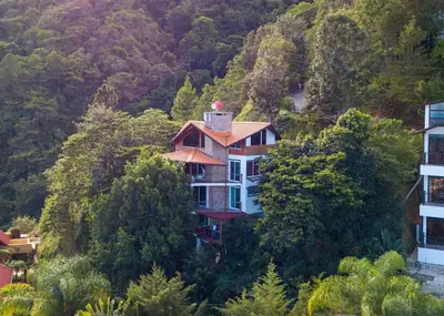 a house on the side of a hill with trees at Mansion Dubai-Mountain-Jacuzzi-4BR-Jamaca De Dios in Jarabacoa